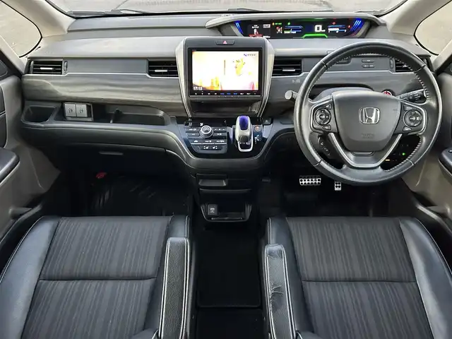 ホンダ フリード ハイブリット EX 岡山県 2016(平28)年 5.4万km ホワイトオーキッドパール 登録時走行距離58334km/ワンオーナー/純正9インチナビ/フルセグTV(AM/FM/CD/DVD/Bluetooth/HDMI)/純正12.8インチフリップダウンモニター/バックカメラ/両側パワースライドドア/ビルトインETC/ホンダセンシング/・アダプティブクルーズコントロール/・レーンキープアシスト/・衝突軽減ブレーキ/・路外逸脱抑制機能/・先行車発進お知らせ機能/・標識認識機能/横滑り抑制機能/車両接近通報装置/フロントガラス熱線スイッチ/D/N席シートヒーター/USB入力端子/ロールサンシェード/ハーフレザーシート/15インチ純正AW　/純正フロアマット