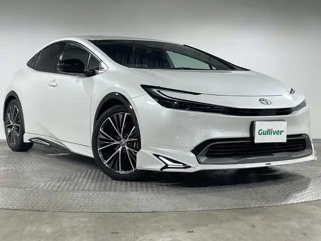 トヨタ プリウス Z 神奈川県 2023(令5)年 3万km プラチナホワイトパールマイカ 純正12.3型ディスプレイオーディオ/AM FM USB Bluetooth /パノラマミックビューモニター/モデリスタエアロ/セーフティセンス/トヨタチームメイト/アドバンストパーク/ブラインドスポットモニター/前後パーキングセンサーソナー/レーンチェンジアシスト/フロントクロストラフィックアラート/後退速度抑制/発進遅れ告知/安心降車アシスト/パーキングアシスト/ディスプレイオーディオプラス/純正前方ドライブレコーダー（ナビ連動）/デジタルインナーミラー/ETC2.0/スマートキー/プッシュスタート/パワーバックドア/ブレーキオートホールド/アクセサリーコンセント/D席パワーポジションメモリーシート/前席エアーシート/合皮巻ステアリング/ステアリングヒーター/合皮スポーツシート/リヤシートマインダー/オートライト/オートハイビーム/LEDヘッドライト/LEDライン発光/純正19AW