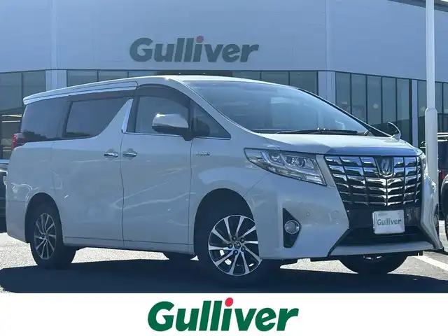 トヨタ アルファードハイブリット X 島根県 2015(平27)年 10.8万km ラグジュアリーホワイトパールクリスタルシャインガラスフレーク 登録時走行距離107901km/ワンオーナー/アルパイン10インチSD純正ナビ/アルパイン12.8インチフリップダウンモニター/フルセグTV/横滑り防止装置/衝突被害軽減ブレーキ/バックカメラ/クリアランスソナー/インテリジェントクリアランスソナー/両側パワースライドドア/レーダークルーズコントロール/ETC2.0/EVモード/エコモード/ステアリングスイッチ/オートライト/LEDヘッドライト/フォグランプ/プッシュスタート/スマートキー×2/ウィンカーミラー/禁煙車/保証書/取扱説明書