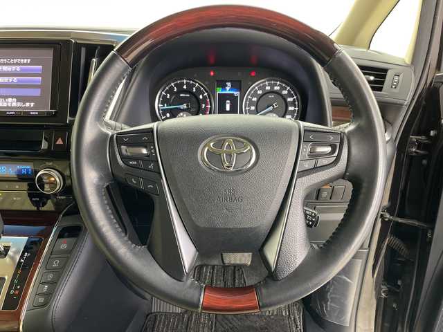 トヨタ ヴェルファイア V 道央・札幌 2015(平27)年 5.2万km バーニングブラッククリスタルシャインガラスフレーク ・4WD/・ワンオーナー/・純正ナビ/・BT&CD&DVD&SD＆フルセグTV/・バックカメラ/・純正フリップダウンモニター/・両側パワースライドドア/・助手席ロングスライド/・クルーズコントロール/・ハーフレザーシート/・D席メモリ付パワーシート/・ビルトインETC/・TVキャンセラー/・オットマン/・ステアリングスイッチ/・オートライト/・LEDヘッドライト/・プッシュスタート/・スマートキー/・スペアキー×1