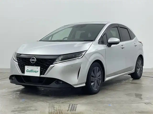 日産 ノート X 岡山県 2021(令3)年 2万km ブリリアントシルバー 純正9インチナビ/・CarPlay/Bluetooth/フルセグTV/HDMI/アラウンドビューモニター/デジタルインナーミラー/ワイヤレス充電/ETC/ドライブレコーダー（前）/LEDヘッドライト/エマージェンシーブレーキ/車線逸脱警報/コーナーセンサー/オートハイビーム/オートライト/ブラインドスポットモニター/オートブレーキホールド/電動パーキング/ドアバイザー/純正フロアマット/新車保証書/取扱説明書/スペアキー×１