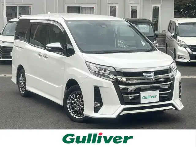 トヨタ ノア ハイブリッド Si ダブルバイビーⅢ 島根県 2021(令3)年 7.3万km ホワイトパールクリスタルシャイン 純正１０インチSDナビ　/(AM/FM/フルセグTVＤＶＤ再生/Ｂｌｕｅｔｏｏｔｈ接続)　/ビルトインＥＴＣ　/バックカメラ/両側パワースライドドア　/クルーズコントロール/前後コーナーセンサー　/レーンアシスト　/プリクラッシュセーフティ　/前席シートヒーター　/オートハイビーム／ライト　/純正ＬＥＤヘッドライト/純正16インチアルミホイール/純正フロアマット