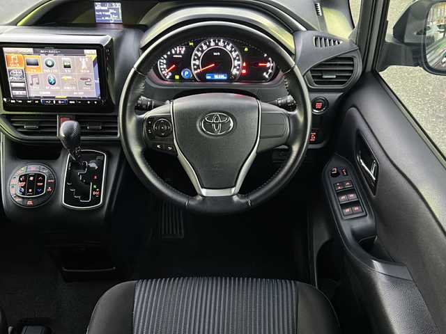 トヨタ ヴォクシー ZS 煌 佐賀県 2015(平27)年 9.7万km アイスチタニウムマイカメタリック エンジンスタートボタン/保証書/取扱説明書/記録簿/MTモード付AT/アイドリングストップ/スマートキー/スペアキー有/Bluetooth接続/後席用モニター/CD再生/USB入力端子/ビルトインETC/バックカメラ/ワンセグTV/メモリナビ/３列シート/前後ドライブレコーダー/ウォークスルー/両側パワースライドドア/ABS/純正アルミホイール/レーンキープアシスト/オートライト/LEDライト/革巻ステアリング/ステアリングスイッチ