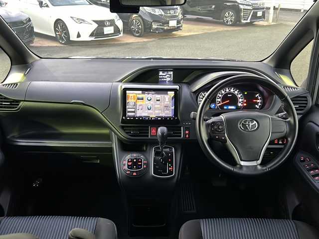 トヨタ ヴォクシー ZS 煌 佐賀県 2015(平27)年 9.7万km アイスチタニウムマイカメタリック エンジンスタートボタン/保証書/取扱説明書/記録簿/MTモード付AT/アイドリングストップ/スマートキー/スペアキー有/Bluetooth接続/後席用モニター/CD再生/USB入力端子/ビルトインETC/バックカメラ/ワンセグTV/メモリナビ/３列シート/前後ドライブレコーダー/ウォークスルー/両側パワースライドドア/ABS/純正アルミホイール/レーンキープアシスト/オートライト/LEDライト/革巻ステアリング/ステアリングスイッチ