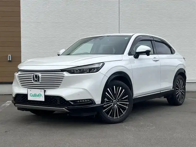 ホンダ ヴェゼル ハイブリッド e:HEV Z 秋田県 2021(令3)年 3.7万km プラチナホワイトパール ４WD/衝突軽減システム/LEDヘッドライト/社外１８インチアルミ（冬タイヤ装着）/スマートキー/アイドリングストップ/プッシュスタート/コーナーセンサー/クルーズコントロール追従走行あり/ダウンヒルアシストコントロール/オートマチックハイビーム/レーンキープアシスト/ブラインドスポットモニター/ステアリングスイッチ/ステアリングヒーター/パドルシフト/前席シートヒーター/ビルトインETC/ドライブレコーダー/電動リアゲート/電動パーキングブレーキ/オートブレーキホールド機能/社外フロアマット/社外ドアバイザー/オートライト/オートエアコン/パワーステアリング/パワーウィンドウ/横滑り防止/盗難防止装置/寒冷地仕様/電動格納ウィンカーミラー