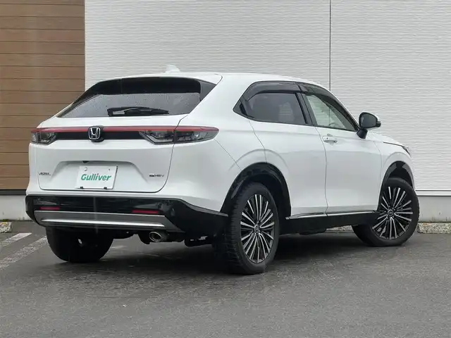 ホンダ ヴェゼル ハイブリッド e:HEV Z 秋田県 2021(令3)年 3.7万km プラチナホワイトパール ４WD/衝突軽減システム/LEDヘッドライト/社外１８インチアルミ（冬タイヤ装着）/スマートキー/アイドリングストップ/プッシュスタート/コーナーセンサー/クルーズコントロール追従走行あり/ダウンヒルアシストコントロール/オートマチックハイビーム/レーンキープアシスト/ブラインドスポットモニター/ステアリングスイッチ/ステアリングヒーター/パドルシフト/前席シートヒーター/ビルトインETC/ドライブレコーダー/電動リアゲート/電動パーキングブレーキ/オートブレーキホールド機能/社外フロアマット/社外ドアバイザー/オートライト/オートエアコン/パワーステアリング/パワーウィンドウ/横滑り防止/盗難防止装置/寒冷地仕様/電動格納ウィンカーミラー