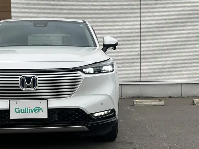 ホンダ ヴェゼル ハイブリッド e:HEV Z 秋田県 2021(令3)年 3.7万km プラチナホワイトパール ４WD/衝突軽減システム/LEDヘッドライト/社外１８インチアルミ（冬タイヤ装着）/スマートキー/アイドリングストップ/プッシュスタート/コーナーセンサー/クルーズコントロール追従走行あり/ダウンヒルアシストコントロール/オートマチックハイビーム/レーンキープアシスト/ブラインドスポットモニター/ステアリングスイッチ/ステアリングヒーター/パドルシフト/前席シートヒーター/ビルトインETC/ドライブレコーダー/電動リアゲート/電動パーキングブレーキ/オートブレーキホールド機能/社外フロアマット/社外ドアバイザー/オートライト/オートエアコン/パワーステアリング/パワーウィンドウ/横滑り防止/盗難防止装置/寒冷地仕様/電動格納ウィンカーミラー
