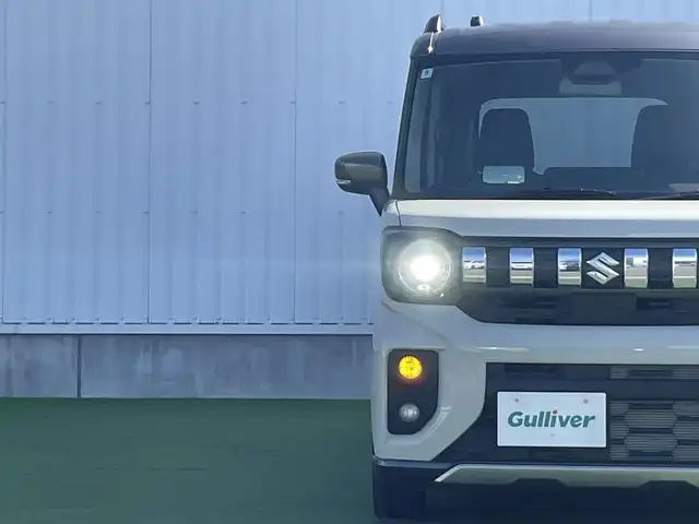 スズキ スペーシア ギア HYBRID XZ 香川県 2024(令6)年 0.3万km 黄Ⅱ ヘッドアップディスプレイ/両側パワースライドドア/シートヒーター/ステアリングヒーター/スズキセーフティサポート/→デュアルカメラブレーキサポート（衝突軽減）/→車線逸脱抑制機能/→アダプティブクルーズコントロール/→誤発進抑制機能/→標識認識機能/ルーフレール/ステアリングヒーター/ステアリングリモコン/LEDオートライト/LEDフォグランプ/電動格納ミラー（ウィンカー付）/12V電源/後席サンシェード/後席オットマン/スマートキー