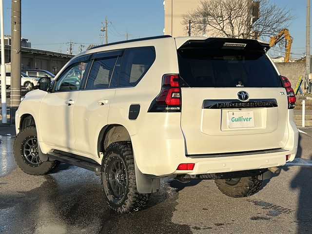 トヨタ ランドクルーザー プラド TX Lパッケージ 石川県 2022(令4)年 4.3万km ホワイトパールクリスタルシャイン サンルーフ/ベージュ革シート/メーカーOPナビ/全方位カメラ（フロント/サイド/リア）/プリクラッシュセーフティ/レーダークルーズコントロール/レーンキープアシスト/パーキングサポートブレーキ/社外足回り/・リフトアップ/ビルトインETC2.0/前後ドライブレコーダー/エアシート/シートヒーター/オートライト/オートハイビーム/LEDヘッドライト/プッシュスタート/ウッドコンビステアリング/ステアリングスイッチ/オートドアミラー/ウィンカーミラー/フロアマット/ドアバイザー