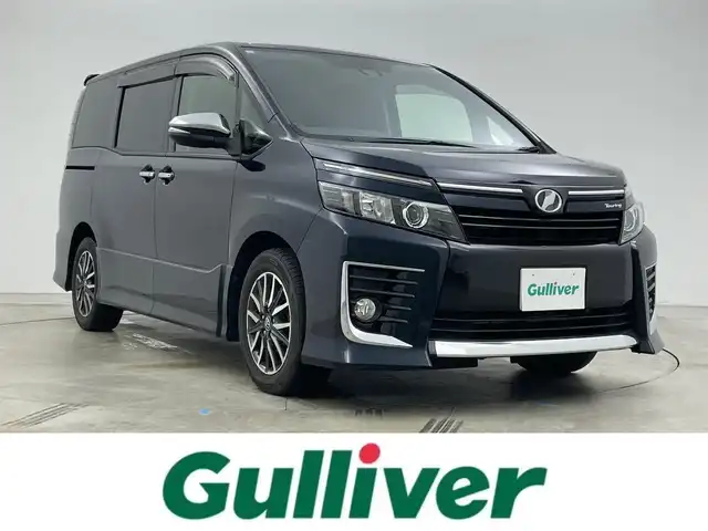 トヨタ ヴォクシー ZS 岡山県 2017(平29)年 9.8万km プレシャスブラックパール 社外7インチナビ/型番:CN-RE03WD/　「フルセグ/Bluetooth/DVD」/オートハイビーム/LEDヘッドライト（AUTO機能付き）/前席シートヒーター/衝突軽減ブレーキシステム/車線逸脱防止システム/横滑り防止装置/ビルトインETC/純正16インチアルミホイール/社外フロアマット/プッシュスタート/後席サンシェイイド/スマートキー×１