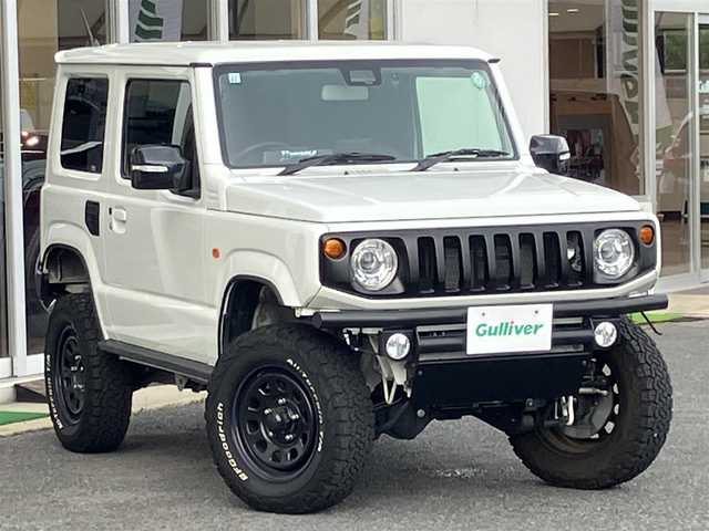 スズキ ジムニー XC 山口県 2021(令3)年 1.5万km ピュアホワイトP ワンオーナー/APIO静香御前マフラー/TANIGUCHI SOLVE AC60サス/　6cmリフトアップキット取り付け/APIOタクティカルリアバンパー/KLCヘリテージトラディショナルFバンパー/10インチメモリーナビ・フルセグTV/バックカメラ/前後ドライブレコーダー/スマートキー/フロントシートヒーター/クルーズコントロール/レーンアシスト/衝突被害軽減システム/LEDオートライト/フォグランプ