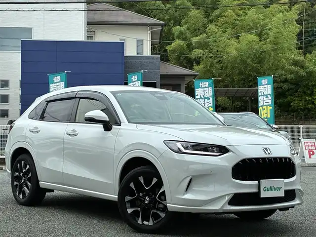 ホンダ ＺＲ－Ｖ ハイブリッド e:HEV Z 熊本県 2024(令6)年 1.3万km プラチナホワイトパール BOSEサウンド/純正ナビ/【フルセグTV/Bluetooth/USB/ラジオ】/全方位カメラ/レーダークルーズコントロール/パドルシフト/衝突軽減ブレーキ/レーンキープアシスト/先行車発進お知らせ機能/パーキングセンサー/ダウンヒルアシスト/標識認識機能/黒革シート/前席パワーシート/運転席シートメモリ/前席シートヒーター/ビルトインETC2.0/前後ドライブレコーダー（DRH-224SD）/横滑り防止機能/ブレーキホールド/純正18インチAW/ワイヤレス充電/ステアリングヒーター/革巻きステアリング/ステアリングスイッチ/オートライト/LEDヘッドライト/純正フロアマット/ドアバイザー/保証書/取扱説明書