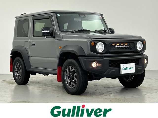 スズキ ジムニー シエラ JC 愛知県 2024(令6)年 1.1万km ミディアムグレー 衝突軽減ブレーキシステム/レーンキープアシスト/レーダークルーズコントロール/社外メモリナビゲーション/（CD/DVD/SD/BT/フルセグTV）/バックカメラ/ビルトインETC/ナビ連動ドライブレコーダー/レーダー探知機/前席シートヒーター/ミラーヒーター/LEDヘッドライト/電格ミラー/ドアバイザー/社外シーケンシャルテールランプ/社外マフラー/純正フロアマット/純正15インチアルミホイール