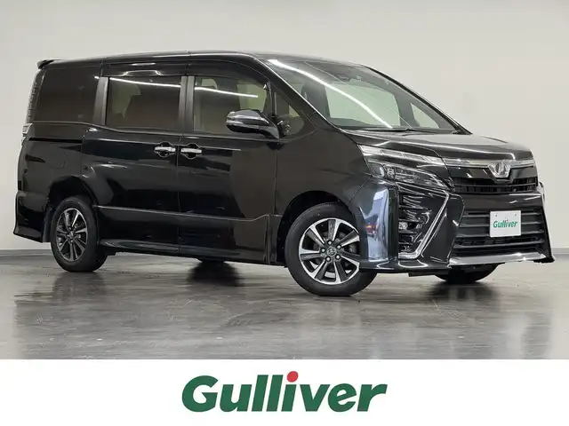 トヨタ ヴォクシー ZS 煌 三重県 2018(平30)年 2.7万km イナズマスパーキングブラックガラスフレーク ガソリン/FF/MTモード付インパネCVT/純正 10インチナビ NSZT-Z66T/（AM/FM/CD/DVD/TV/SD/SDREC/Bluetooth）/バックカメラ/両側パワースライドドア/ビルトイン ETC/Toyota Safety Sense/・プリクラッシュセーフティ［PCS］/・レーンディパーチャーアラート［LDA］/・オートハイビーム［AHB］/・横滑り防止装置［TRC］/など/装備/・クルーズコントロール/・左右独立温度調整＆後席独立調整オートエアコン/・オートライト/・LED ヘッドランプ＆フロントフォグランプ/・ステアリングスイッチ/・プッシュスタート/・充電用USBジャックx2/・純正16inAW/・保/取/・スマートキーx1/など