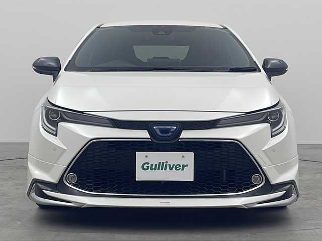 トヨタ カローラツーリング ハイブリッド ダブルバイビー 三重県 2019(令1)年 7.2万km ホワイトパールクリスタルシャイン 禁煙車/純正9インチナビ/（Bluetooth・MiraCast）/バックカメラ/トヨタセーフティセンス/・プリクラッシュセーフティ/・オートマチックハイビーム/・レーントレーシングアシスト/・ロードサインアシスト/・レーダークルーズコントロール/社外フルエアロ/電子パーキング/ブラインドスポットモニター/前席シートヒーター/ステアリングススイッチ/ビルトインETC2.0                                              /スペアタイヤ