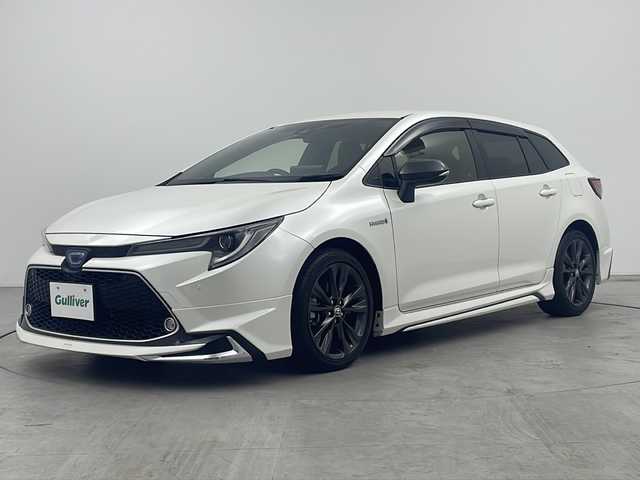 トヨタ カローラツーリング ハイブリッド ダブルバイビー 三重県 2019(令1)年 7.2万km ホワイトパールクリスタルシャイン 禁煙車/純正9インチナビ/（Bluetooth・MiraCast）/バックカメラ/トヨタセーフティセンス/・プリクラッシュセーフティ/・オートマチックハイビーム/・レーントレーシングアシスト/・ロードサインアシスト/・レーダークルーズコントロール/社外フルエアロ/電子パーキング/ブラインドスポットモニター/前席シートヒーター/ステアリングススイッチ/ビルトインETC2.0                                              /スペアタイヤ