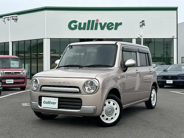 スズキ ラパン ショコラ G 愛媛県 2013(平25)年 3.3万km シャンパンピンクPM 登録時走行距離:32281km/スマートキー/純正フロアマット/純正アルミホイール/本革ステアリング/ツートンレザーシート/純正FM/CDプレーヤー/シガーソケット/ＡＣ/HIDヘッドライト/アイドリングストップ/盗難防止装置/ABS/パワステ/パワーウィンドウ/エアバッグ