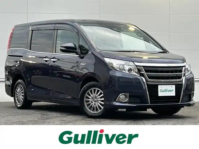 トヨタ エスクァイア ハイブリッド Xi 佐賀県 2016(平28)年 5.5万km ダークバイオレットマイカメタリック トヨタセーフティセンスC/・プリクラッシュセーフティ/・レーンディパーチャーアラート/・オートマチックハイビーム/純正SDナビ/・バックカメラ/・フルセグTV/BT/CD/DVD/純正フリップダウンモニター/純正ドラレコ/(DRT-H66A：SDなし動作確認なし)/両側パワースライドドア/純正15インチAW/LEDヘッドライト/シートヒーター/プッシュスタート/ETC/スペアキー×1/取扱説明書