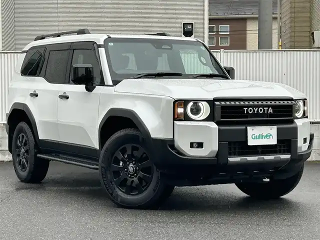 トヨタ ランドクルーザー ２５０ ZX ファーストエディション 栃木県 2024(令6)年 0.4万km プラチナホワイトパールマイカ 丸目型Bi-Beam LED ヘッドランプ（オートレベリング機能付）＋LED クリアランスランプ（おむかえ照明機能付）＆LEDデイタイムランニングランプ/マルチテレインセレクト/電動リヤデフロック/チルト＆スライド電動ムーンルーフ/デジタルインナーミラー/カラーヘッドアップディスプレイ/JBLプレミアムサウンドシステム/ToyotaSafetySense/・プリクラッシュセーフティ/・緊急時操舵支援＋フロントクロスト/ラフィックアラート［FCTA］＋レーンチェンジアシスト［LCA］/・レーントレーシングアシスト［LTA］＋レーンディパーチャー/アラート［LDA］/・レーダークルーズコントロール/・オートマチックハイビーム［AHB］/・ロードサインアシスト［RSA］/・ドライバー異常時対応システム/・プロアクティブドライビングアシスト［PDA］/・発進遅れ告知機能［TMN］/・ブラインドスポットモニター［BSM］＋安心降車アシスト［SEA］＋/後方車両接近告知＋周辺車両接近時サポート＋後方車両への接近警報＋セカンダリーコリジョンブレーキ/トヨタチームメイト/パーキングサポートブレーキ/パノラミックビューモニター/12.3インチナビ