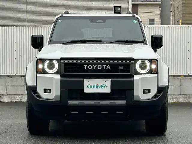 トヨタ ランドクルーザー ２５０ ZX ファーストエディション 栃木県 2024(令6)年 0.4万km プラチナホワイトパールマイカ 丸目型Bi-Beam LED ヘッドランプ（オートレベリング機能付）＋LED クリアランスランプ（おむかえ照明機能付）＆LEDデイタイムランニングランプ/マルチテレインセレクト/電動リヤデフロック/チルト＆スライド電動ムーンルーフ/デジタルインナーミラー/カラーヘッドアップディスプレイ/JBLプレミアムサウンドシステム/ToyotaSafetySense/・プリクラッシュセーフティ/・緊急時操舵支援＋フロントクロスト/ラフィックアラート［FCTA］＋レーンチェンジアシスト［LCA］/・レーントレーシングアシスト［LTA］＋レーンディパーチャー/アラート［LDA］/・レーダークルーズコントロール/・オートマチックハイビーム［AHB］/・ロードサインアシスト［RSA］/・ドライバー異常時対応システム/・プロアクティブドライビングアシスト［PDA］/・発進遅れ告知機能［TMN］/・ブラインドスポットモニター［BSM］＋安心降車アシスト［SEA］＋/後方車両接近告知＋周辺車両接近時サポート＋後方車両への接近警報＋セカンダリーコリジョンブレーキ/トヨタチームメイト/パーキングサポートブレーキ/パノラミックビューモニター/12.3インチナビ