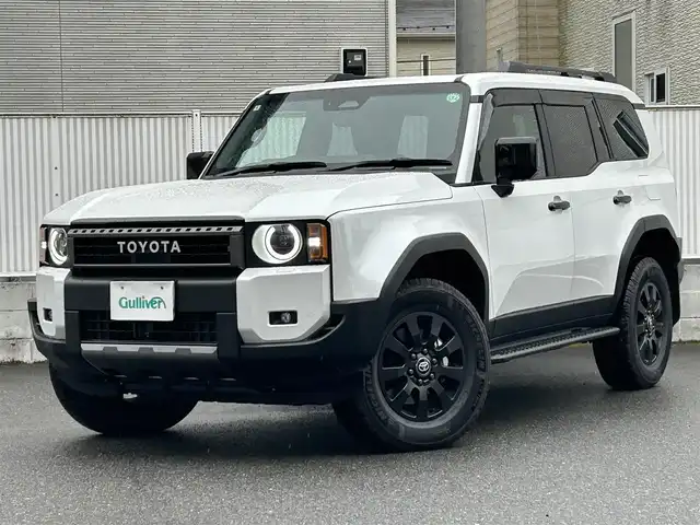 トヨタ ランドクルーザー ２５０ ZX ファーストエディション 栃木県 2024(令6)年 0.4万km プラチナホワイトパールマイカ 丸目型Bi-Beam LED ヘッドランプ（オートレベリング機能付）＋LED クリアランスランプ（おむかえ照明機能付）＆LEDデイタイムランニングランプ/マルチテレインセレクト/電動リヤデフロック/チルト＆スライド電動ムーンルーフ/デジタルインナーミラー/カラーヘッドアップディスプレイ/JBLプレミアムサウンドシステム/ToyotaSafetySense/・プリクラッシュセーフティ/・緊急時操舵支援＋フロントクロスト/ラフィックアラート［FCTA］＋レーンチェンジアシスト［LCA］/・レーントレーシングアシスト［LTA］＋レーンディパーチャー/アラート［LDA］/・レーダークルーズコントロール/・オートマチックハイビーム［AHB］/・ロードサインアシスト［RSA］/・ドライバー異常時対応システム/・プロアクティブドライビングアシスト［PDA］/・発進遅れ告知機能［TMN］/・ブラインドスポットモニター［BSM］＋安心降車アシスト［SEA］＋/後方車両接近告知＋周辺車両接近時サポート＋後方車両への接近警報＋セカンダリーコリジョンブレーキ/トヨタチームメイト/パーキングサポートブレーキ/パノラミックビューモニター/12.3インチナビ