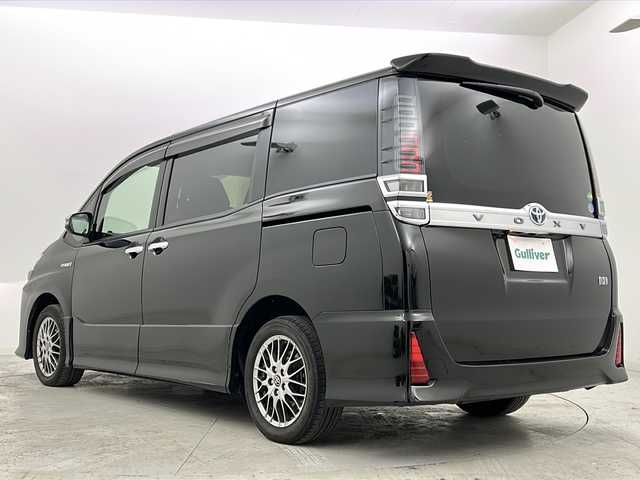 トヨタ ヴォクシー ハイブリッド ZS 煌 宮城県 2018(平30)年 5.7万km イナズマスパーキングブラックガラスフレーク 禁煙車/トヨタセーフティーセンス/・プリクラッシュセーフティーシステム/・オートマチックハイビーム/・レーンディバ―チャーアラート/・クルーズコントロール/前席シートヒーター/純正9インチナビ/（BT.AM.FM.CD.DVD.SD）/バックカメラ/フルセグテレビ/ビルトインETC2.0/純正ドライブレコーダー（F）/両側パワースライドドア/革巻きステアリング/ステアリングスイッチ/プッシュスタート/スマートキー/スペアキー/3列シート/ロールサンシェード/シートバックテーブル/純正フロアマット/純正ドアバイザー/LEDヘッドライト/LEDフォグランプ/純正16インチアルミホイール/アイドリングストップ/横滑り防止機能/アイドリングストップ