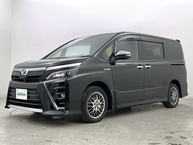 トヨタ ヴォクシー ハイブリッド ZS 煌 宮城県 2018(平30)年 5.7万km イナズマスパーキングブラックガラスフレーク 禁煙車/トヨタセーフティーセンス/・プリクラッシュセーフティーシステム/・オートマチックハイビーム/・レーンディバ―チャーアラート/・クルーズコントロール/前席シートヒーター/純正9インチナビ/（BT.AM.FM.CD.DVD.SD）/バックカメラ/フルセグテレビ/ビルトインETC2.0/純正ドライブレコーダー（F）/両側パワースライドドア/革巻きステアリング/ステアリングスイッチ/プッシュスタート/スマートキー/スペアキー/3列シート/ロールサンシェード/シートバックテーブル/純正フロアマット/純正ドアバイザー/LEDヘッドライト/LEDフォグランプ/純正16インチアルミホイール/アイドリングストップ/横滑り防止機能/アイドリングストップ