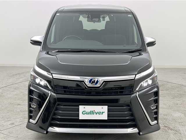 トヨタ ヴォクシー ハイブリッド ZS 煌 宮城県 2018(平30)年 5.7万km イナズマスパーキングブラックガラスフレーク 禁煙車/トヨタセーフティーセンス/・プリクラッシュセーフティーシステム/・オートマチックハイビーム/・レーンディバ―チャーアラート/・クルーズコントロール/前席シートヒーター/純正9インチナビ/（BT.AM.FM.CD.DVD.SD）/バックカメラ/フルセグテレビ/ビルトインETC2.0/純正ドライブレコーダー（F）/両側パワースライドドア/革巻きステアリング/ステアリングスイッチ/プッシュスタート/スマートキー/スペアキー/3列シート/ロールサンシェード/シートバックテーブル/純正フロアマット/純正ドアバイザー/LEDヘッドライト/LEDフォグランプ/純正16インチアルミホイール/アイドリングストップ/横滑り防止機能/アイドリングストップ