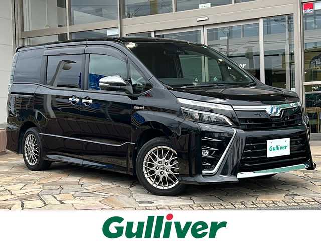 トヨタ ヴォクシー ハイブリッド ZS 煌Ⅱ 静岡県 2019(平31)年 8.2万km ブラック 【主要装備】/純正１０インチナビ　/フルセグテレビ　/純正１２インチフリップダウンモニター　/両側パワースライドドア　/純正１６インチアルミホイール　/前席シートヒーター　/ＥＴＣ　/ステアリングスイッチ　/スペアキー有り/プッシュスタート/スマートキー/クルーズコントロール/オートマチックハイビーム/プリクラッシュセーフティ
