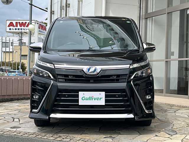 トヨタ ヴォクシー ハイブリッド ZS 煌Ⅱ 静岡県 2019(平31)年 8.2万km ブラック 【主要装備】/純正１０インチナビ　/フルセグテレビ　/純正１２インチフリップダウンモニター　/両側パワースライドドア　/純正１６インチアルミホイール　/前席シートヒーター　/ＥＴＣ　/ステアリングスイッチ　/スペアキー有り/プッシュスタート/スマートキー/クルーズコントロール/オートマチックハイビーム/プリクラッシュセーフティ