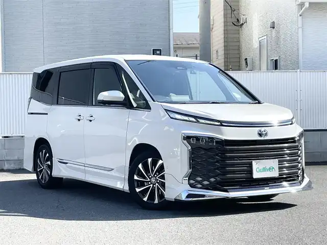 トヨタ ヴォクシー ハイブリッド S－Z 栃木県 2022(令4)年 1.7万km ホワイトパールクリスタルシャイン ワンオーナー/モデリスタエアロ/純正ナビ/（DVD/BT/CD/HDMI/フルセグTV/Miracast/USB）/純正フリップダウンモニター/全方位カメラ/両側パワースライドドア/ヘッドアップディスプレイ/デジタルインナーミラー/パワーバックドア/レーダークルーズコントロール/パーキングアシスト/レーンキープアシスト/オートマチックハイビーム/ハンドルヒーター/ハーフレザーシート/シートヒーター/ドライブレコーダー/2.0ETC/ドアバイザー/保証書/取説/スペアキー