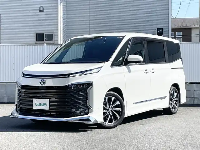 トヨタ ヴォクシー ハイブリッド S－Z 栃木県 2022(令4)年 1.7万km ホワイトパールクリスタルシャイン ワンオーナー/モデリスタエアロ/純正ナビ/（DVD/BT/CD/HDMI/フルセグTV/Miracast/USB）/純正フリップダウンモニター/全方位カメラ/両側パワースライドドア/ヘッドアップディスプレイ/デジタルインナーミラー/パワーバックドア/レーダークルーズコントロール/パーキングアシスト/レーンキープアシスト/オートマチックハイビーム/ハンドルヒーター/ハーフレザーシート/シートヒーター/ドライブレコーダー/2.0ETC/ドアバイザー/保証書/取説/スペアキー