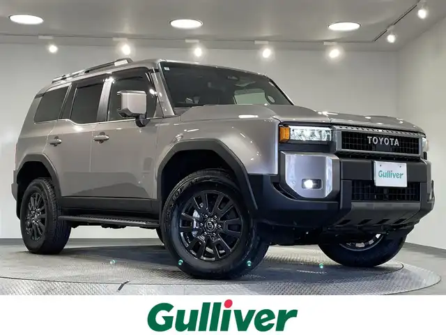 トヨタ ランドクルーザー ２５０ VX 愛知県 2025(令7)年 0.1万km アバンギャルドブロンズメタリック 純正１２．３インチディスプレイナビ　/(AM/FM/Bluetooth/Miracast/HDMI/フルセグTV/USB)/サンルーフ　/パノラミックビューモニター　/トヨタセーフティセンス　/　　-衝突軽減ブレーキ/　　-車線逸脱警報/　　-レーダークルーズコントロール/　　-オートマチックハイビーム/　　-ロードサインアシスト/　　-発進告知機能/シートヒーター　/シートベンチレーション/ビルトインＥＴＣ２．０　/デジタルインナーミラー　/ステアリングヒーター　/ブラインドスポットモニター/クリアランスソナー/D席パワーシート/ルーフレール　/三眼ＬＥＤヘッドライト/フォグランプ/黒レザーシート/純正フロアマット/スペアタイヤ有