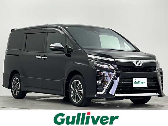 トヨタ ヴォクシー ZS 煌Ⅱ 大阪府 2020(令2)年 6.3万km ブラック 純正9インチSDナビ【NSZT-Y64T】/【AM/FM/CD/Bluetooth/フルセグTV】/純正12インチフリップダウンモニター/バックカメラ/ビルトインETC/前方ドライブレコーダー【DRT-H64A】/先行車発進お知らせ機能/2列目ロールサンシェード/オートライト/純正フロアマット/純正16インチAW/トヨタセーフティセンス/・プリクラッシュセーフティ/・レーンディパーチャーアラート/・オートマチックハイビーム/・クリアランスソナー/・パーキングサポートブレーキ/ドアバイザー/横滑り防止装置/盗難防止装置