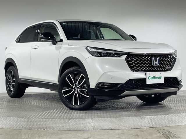 ホンダ ヴェゼル ハイブリッド e:HEV Z 神奈川県 2023(令5)年 1万km プラチナホワイトパール RSグレード海外ホンダ純正グリル/ホンダコネクト9型ディスプレイ/インターナビ/フルセグ USB　Bluetooth/ハンズフリーパワーバックドア/ETC2.0/ワイヤレス充電/後退出庫サポート/信号情報活用支援システム/ホンダセンシング/ブラインドスポットインフォメーション/衝突軽減ブレーキ/後方誤発進抑制機能/歩行者事故低減ステアリング/アダブティブクルーズコントロール/車線維持支援システム/パーキングセンサーシステム/誤発進抑制機能/近距離衝突軽減ブレーキ/路外逸脱抑制機能/先行車発進お知らせ機能/オートハイビーム/革巻きステアリング/パドルシフト/ステアリングヒーター/合皮/ファブリックコンビシート/前席シートヒーター/前後USBジャック/ダウンヒルアシストコントロール/社外前後ドライブレコーダー/電動パーキングブレーキ/オートブレーキホールド/プッシュスタート/スマートキー/LEDヘッド/フロントフォグランプ/LEDアクティブコーナリングランプ/シーケンシャルターンランプ/純正18ンチアルミホイール/