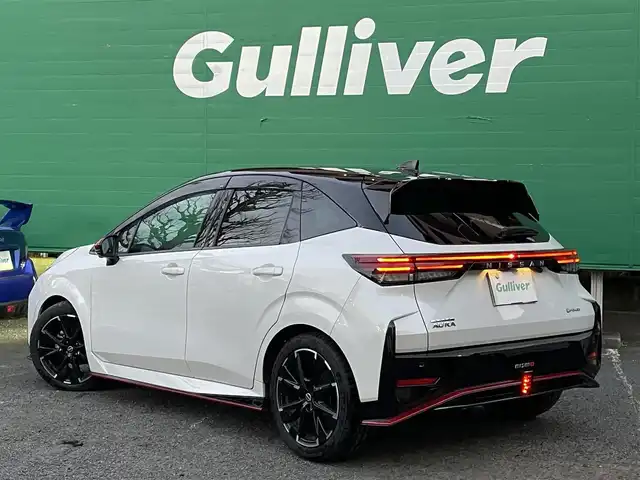 日産 オーラ ニスモ 東京都 2022(令4)年 1.2万km ピュアホワイトパール / スーパーブラック 2トーン ワンオーナー/ブラックルーフ/コネクトナビゲーションシステム/・9インチメモリナビ/（フルセグTV//DVD/Bluetooth/USB//android auto/applecarplay)/・ワイヤレス充電器/・ETC2.0/・プロパイロット/・前席USB電源ソケットタイプC/寒冷地仕様/・ドアミラーヒーター/・革巻きステアリング/・ステアリングヒーター/・シートヒーター(運転席＆助手席)/純正ドライブレコーダー（DH5-S)/全方位運転支援システム/・インテリジェントエマージェンシーブレーキ/・車線逸脱警報/・車線逸脱防止支援システム/・高速方衝突防止支援システム/インテリジェントアラウンドビューモニター/アダプティブLEDヘッドランプ/前後コーナーセンサー/社外ホイール＋スタッドレスタイヤ車載/保証書/取扱説明書/記録簿