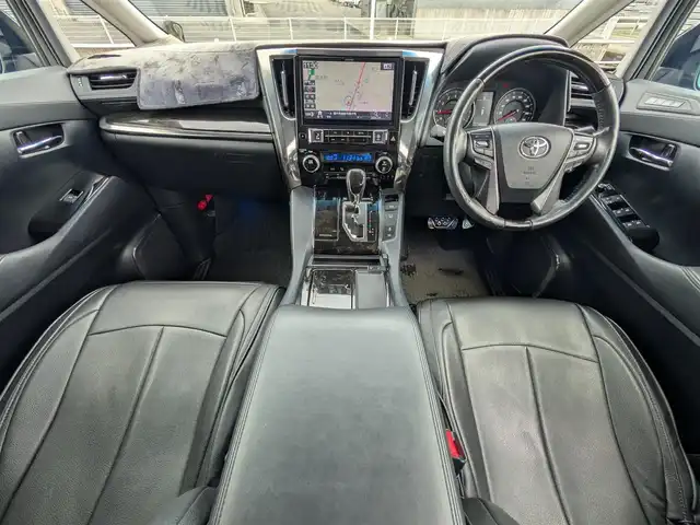 トヨタ ヴェルファイア Z Gエディション 福井県 2015(平27)年 8.9万km バーニングブラッククリスタルシャインガラスフレーク 純正18インチAW/ビルトインETC/レーダークルーズコントロール/衝突被害軽減システム/アイドリングストップ/１００V充電/後席用フリップダウンモニター/前席パワーシート/ステアリングヒーター/オットマン/電動リアゲート/両側パワースライドドア/前方ドライブレコーダー/前後コーナーセンサー/純正10インチメモリナビ（CD/DVD/BT/USB）/横滑り防止装置/盗難防止装置/LEDヘッドライト/スタッドレスタイヤ積込/社外シートカバー/オートホールド