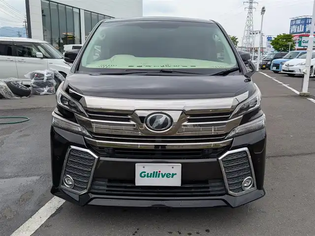 トヨタ ヴェルファイア Z Gエディション 福井県 2015(平27)年 8.9万km バーニングブラッククリスタルシャインガラスフレーク 純正18インチAW/ビルトインETC/レーダークルーズコントロール/衝突被害軽減システム/アイドリングストップ/１００V充電/後席用フリップダウンモニター/前席パワーシート/ステアリングヒーター/オットマン/電動リアゲート/両側パワースライドドア/前方ドライブレコーダー/前後コーナーセンサー/純正10インチメモリナビ（CD/DVD/BT/USB）/横滑り防止装置/盗難防止装置/LEDヘッドライト/スタッドレスタイヤ積込/社外シートカバー/オートホールド