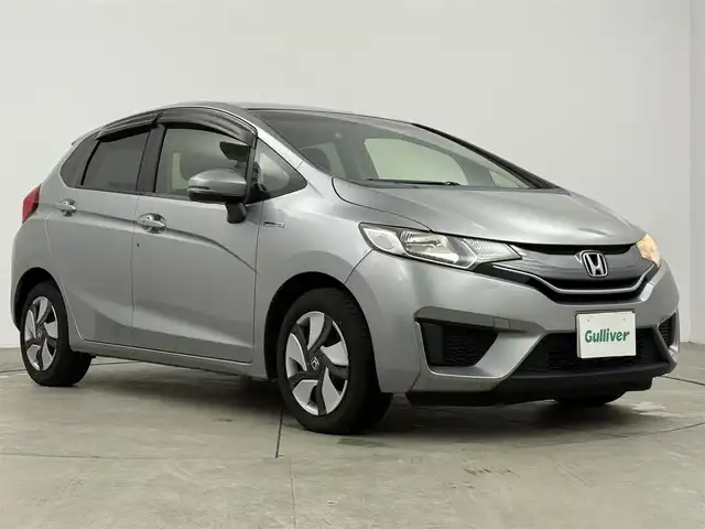 ホンダ フィット ハイブリット Fパッケージ 愛知県 2015(平27)年 9.1万km ティンテッドシルバーM 純正ナビ/（CD/DVD/Bluetooth/ワンセグ）/ETC/バックカメラ/横滑り防止/ステアスイッチ/ECOモード付き/ドアバイザー/電格ミラー/スマートキー/プッシュスタート/ハロゲンヘッドライト/マニュアルレベライザー