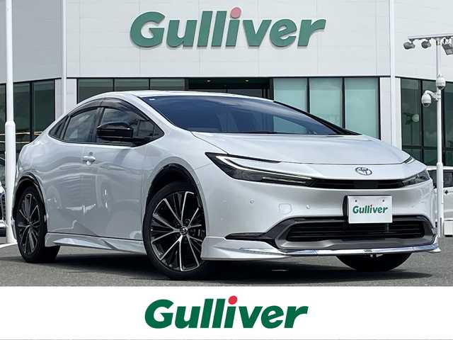 トヨタ プリウス Z 熊本県 2024(令6)年 2.2万km プラチナホワイトパールマイカ ワンオーナー/モデリスタエアロ/純正12.3インチディスプレイ(TV・ナビ機能付)/・AM/FM/USB/Bluetooth/パノラミックビューモニター/ビルトインETC2.0/アドバンストパーク/TVキャンセラー/パワーバックドア/電子パーキングブレーキ/AUTO HOLD機能/100V電源/置くだけ充電/DN席シートヒーター/シートベンチレーション/ISOFIX対応/革巻きステアリング/ステアリングヒーター/ステアリングリモコン/純正19インチアルミホイール/純正LEDヘッドライト/・オートマチックハイビーム/純正フロアマット/純正ドアバイザー/新車保証書/スペアキー１本/トヨタセーフティセンス/・レーダークルーズコントロール/・レーンディパーチャーアラート/・ブラインドスポットモニター/・プリクラッシュセーフティ/・クリアランスソナー/・プロアクティブドライビングアシスト/・リヤクロストラフィックアラート/・後方車両接近告知/・リヤカメラディテクション/・パーキングサポートブレーキ/・安心降車アシスト/・周辺車両接近時サポート/・ロードサインアシスト
