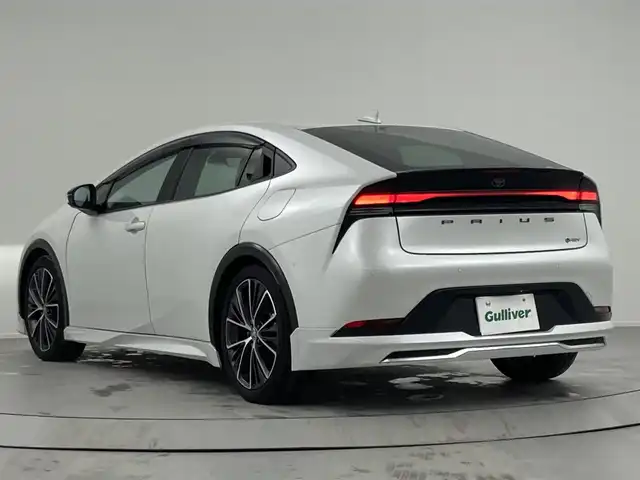 トヨタ プリウス Z 熊本県 2024(令6)年 2.2万km プラチナホワイトパールマイカ ワンオーナー/モデリスタエアロ/純正12.3インチディスプレイ(TV・ナビ機能付)/・AM/FM/USB/Bluetooth/パノラミックビューモニター/ビルトインETC2.0/アドバンストパーク/TVキャンセラー/パワーバックドア/電子パーキングブレーキ/AUTO HOLD機能/100V電源/置くだけ充電/DN席シートヒーター/シートベンチレーション/ISOFIX対応/革巻きステアリング/ステアリングヒーター/ステアリングリモコン/純正19インチアルミホイール/純正LEDヘッドライト/・オートマチックハイビーム/純正フロアマット/純正ドアバイザー/新車保証書/スペアキー１本/トヨタセーフティセンス/・レーダークルーズコントロール/・レーンディパーチャーアラート/・ブラインドスポットモニター/・プリクラッシュセーフティ/・クリアランスソナー/・プロアクティブドライビングアシスト/・リヤクロストラフィックアラート/・後方車両接近告知/・リヤカメラディテクション/・パーキングサポートブレーキ/・安心降車アシスト/・周辺車両接近時サポート/・ロードサインアシスト