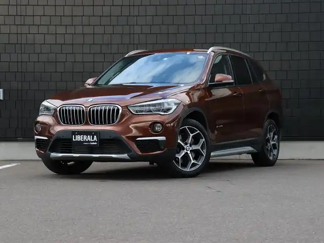 ＢＭＷ Ｘ１ xDrive 20i Xライン 宮城県 2016(平28)年 2.4万km 茶 純正ナビ【ＢＴ／ＣＤ／ＤＶＤ／ＡＵＸ】/ワンオーナー　/インテリジェントセーフティ　/バックカメラ　/パーキングアシスト/コーナーセンサー(前後)　/ルーフレール　/ハーフレザーシート　/ミラー一体型ＥＴＣ　/純正１８インチＡＷ　/ダウンヒルアシストコントロール/プッシュスタート/コンフォートアクセス/LIMスイッチ/MTモード付/純正フロアマット/オートライト/LEDヘッドライト/禁煙車/カラーコード：C29