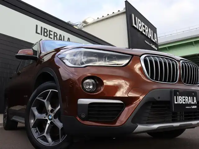 ＢＭＷ Ｘ１ xDrive 20i Xライン 宮城県 2016(平28)年 2.4万km 茶 純正ナビ【ＢＴ／ＣＤ／ＤＶＤ／ＡＵＸ】/ワンオーナー　/インテリジェントセーフティ　/バックカメラ　/パーキングアシスト/コーナーセンサー(前後)　/ルーフレール　/ハーフレザーシート　/ミラー一体型ＥＴＣ　/純正１８インチＡＷ　/ダウンヒルアシストコントロール/プッシュスタート/コンフォートアクセス/LIMスイッチ/MTモード付/純正フロアマット/オートライト/LEDヘッドライト/禁煙車/カラーコード：C29