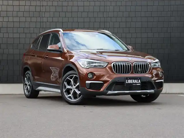 ＢＭＷ Ｘ１ xDrive 20i Xライン 宮城県 2016(平28)年 2.4万km 茶 純正ナビ【ＢＴ／ＣＤ／ＤＶＤ／ＡＵＸ】/ワンオーナー　/インテリジェントセーフティ　/バックカメラ　/パーキングアシスト/コーナーセンサー(前後)　/ルーフレール　/ハーフレザーシート　/ミラー一体型ＥＴＣ　/純正１８インチＡＷ　/ダウンヒルアシストコントロール/プッシュスタート/コンフォートアクセス/LIMスイッチ/MTモード付/純正フロアマット/オートライト/LEDヘッドライト/禁煙車/カラーコード：C29