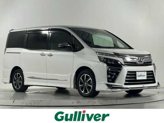 トヨタ ヴォクシー ZS 煌Ⅱ 佐賀県 2019(令1)年 8.2万km ホワイトパールクリスタルシャイン 社外11インチナビ/CD/DVD/フルセグTV/Bluetooth/HDMI/両側パワースライドドア/ワンオーナー/モデリスタフルエアロ/社外12.8インチ後席モニター/社外ステアリング/社外シフトノブ/衝突軽減ブレーキ/レーンキープアシスト/オートハイビーム/横滑り防止/クルーズコントロール/ビルトインETC/USB入電×2/シートカバ-/フロアマット/純正バイザー/純正16インチアルミホイール