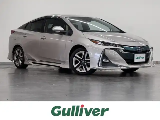 トヨタ プリウス ＰＨＶ S ナビパッケージ 三重県 2017(平29)年 5.1万km スティールブロンドM プラグインハイブリッド/FF/インパネCVT/純正 11.6インチ 縦型ナビ/（AM/FM/USB/iPod/Bluetooth/AUX/TV）/バックカメラ/モデリスタエアロ（F/S/R下）/【OP】ETC2.0/Toyota Safety Sense/・プリクラッシュセーフティ/・レーンディパーチャーアラート（操舵支援付）/・レーダークルコン/・オートハイビーム/・ふらつき検知機能/・【OP】ITS Connect/装備/・【OP】AC100Vアクセサリーコンセント（ヴィークルパワーコネクター付・V2H対応・コンセント2ヶ）/・シートヒーター（D/N）/・ステアリングヒーター/・オートエアコン/・オートライト/・LED ヘッドライト＆フロントフォグランプ/・純正17inAW/・プッシュスタート/・スマートキーx1/・保/など