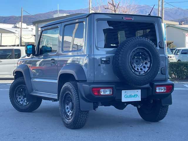 スズキ ジムニー シエラ JC 長野県 2023(令5)年 2.7万km ミディアムグレー 禁煙車/ワンオーナー/純正SDナビ/フルセグTV/バックカメラ/（Bluetooth/CD/DVD/HDMI）/社外１５インチアルミ（ＮＩＴＲＯ　ＰＯＷＥＲ）/前席シートヒーター/背面スペアタイヤ/クルーズコントロール/アイドリングストップ/衝突被害軽減システム/横滑り防止装置/レーンキープアシスト/ダウンヒルアシストコントロール/LEDヘッドライト/ウインカーミラー/社外フロアマット/カーテンエアバッグ/高低速2段切替レバー /ステアリングスイッチ/プッシュスタート/スマートキー