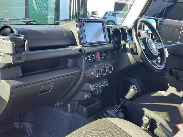 スズキ ジムニー シエラ JC 長野県 2023(令5)年 2.7万km ミディアムグレー 禁煙車/ワンオーナー/純正SDナビ/フルセグTV/バックカメラ/（Bluetooth/CD/DVD/HDMI）/社外１５インチアルミ（ＮＩＴＲＯ　ＰＯＷＥＲ）/前席シートヒーター/背面スペアタイヤ/クルーズコントロール/アイドリングストップ/衝突被害軽減システム/横滑り防止装置/レーンキープアシスト/ダウンヒルアシストコントロール/LEDヘッドライト/ウインカーミラー/社外フロアマット/カーテンエアバッグ/高低速2段切替レバー /ステアリングスイッチ/プッシュスタート/スマートキー