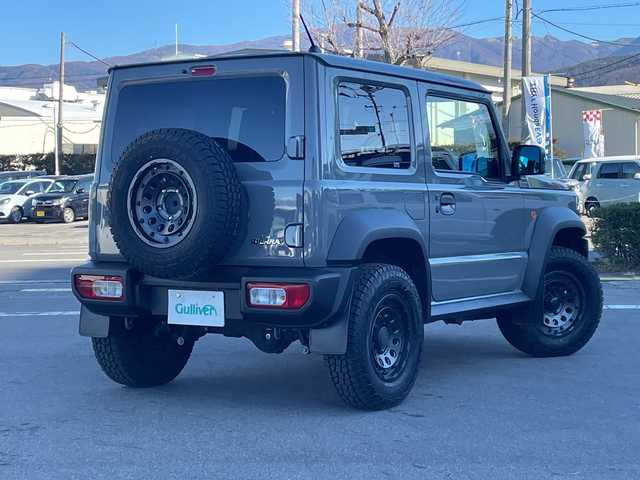 スズキ ジムニー シエラ JC 長野県 2023(令5)年 2.7万km ミディアムグレー 禁煙車/ワンオーナー/純正SDナビ/フルセグTV/バックカメラ/（Bluetooth/CD/DVD/HDMI）/社外１５インチアルミ（ＮＩＴＲＯ　ＰＯＷＥＲ）/前席シートヒーター/背面スペアタイヤ/クルーズコントロール/アイドリングストップ/衝突被害軽減システム/横滑り防止装置/レーンキープアシスト/ダウンヒルアシストコントロール/LEDヘッドライト/ウインカーミラー/社外フロアマット/カーテンエアバッグ/高低速2段切替レバー /ステアリングスイッチ/プッシュスタート/スマートキー