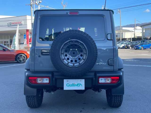 スズキ ジムニー シエラ JC 長野県 2023(令5)年 2.7万km ミディアムグレー 禁煙車/ワンオーナー/純正SDナビ/フルセグTV/バックカメラ/（Bluetooth/CD/DVD/HDMI）/社外１５インチアルミ（ＮＩＴＲＯ　ＰＯＷＥＲ）/前席シートヒーター/背面スペアタイヤ/クルーズコントロール/アイドリングストップ/衝突被害軽減システム/横滑り防止装置/レーンキープアシスト/ダウンヒルアシストコントロール/LEDヘッドライト/ウインカーミラー/社外フロアマット/カーテンエアバッグ/高低速2段切替レバー /ステアリングスイッチ/プッシュスタート/スマートキー